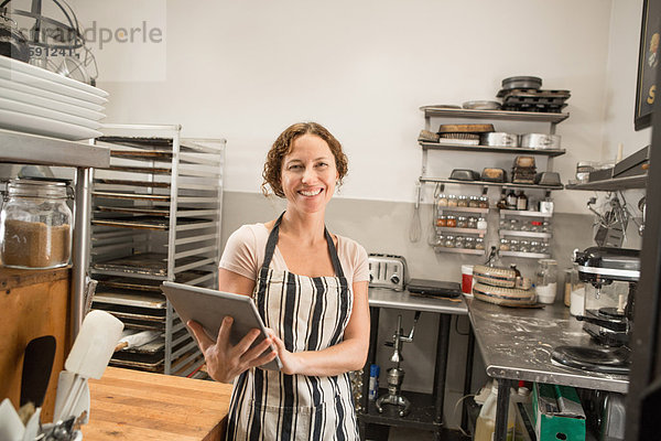 Portrait der Verkäuferin mit digitalem Tablett in der Küche des Landhauses