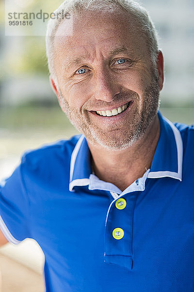 Porträt eines lächelnden reifen Mannes im blauen Hemd