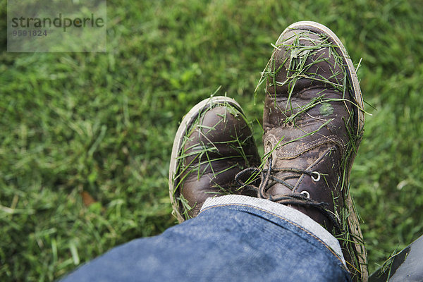 Mans Schuhe mit frisch gemähten Gras bedeckt