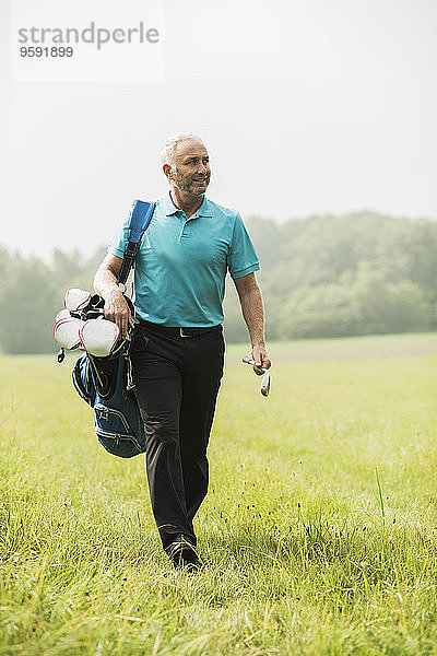 Golfspieler beim Spaziergang auf einer Wiese