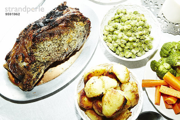 Abendessen mit gebratenem Fleisch  Kartoffeln  Karotten  Brokkoli und Saubohnen auf dem Tisch