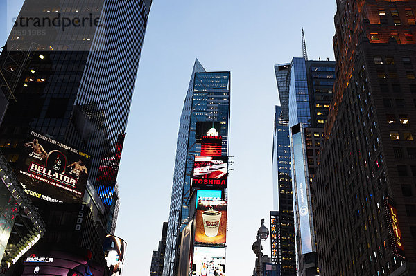 Tiefblick auf Wolkenkratzer und Werbeschilder bei Sonnenuntergang  New York  USA