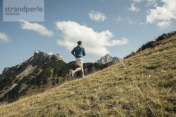 Österreich  Tirol  Tannheimer Tal  junger Mann beim Joggen in den Bergen