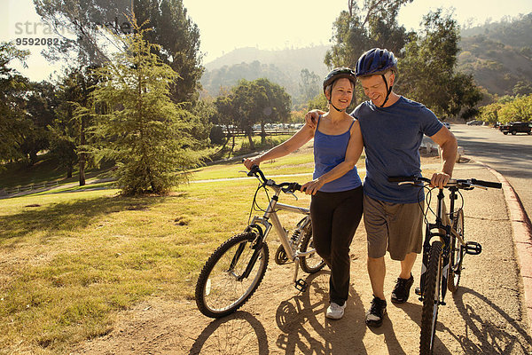 Reife Paare plaudern beim Fahrradfahren im Park