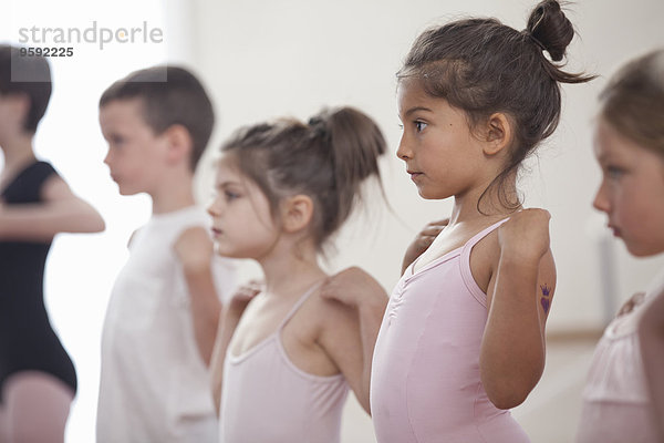 Reihe von Kindern  die in der Ballettschule üben