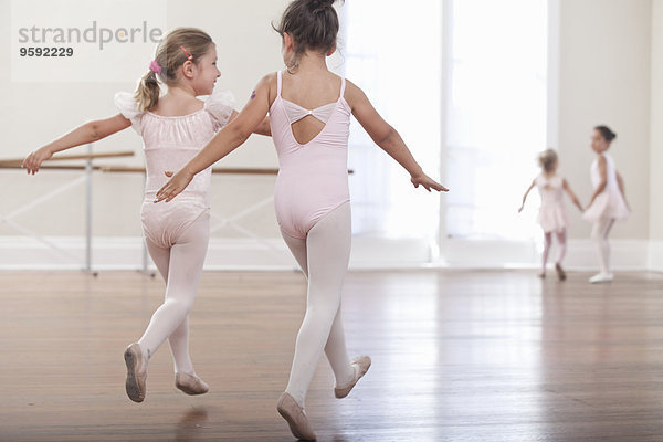 Rückansicht der Mädchen beim Springen in der Ballettschule