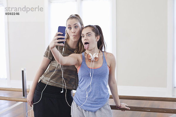 Zwei Teenager-Mädchen nehmen Smartphone Selfie in Ballettschule