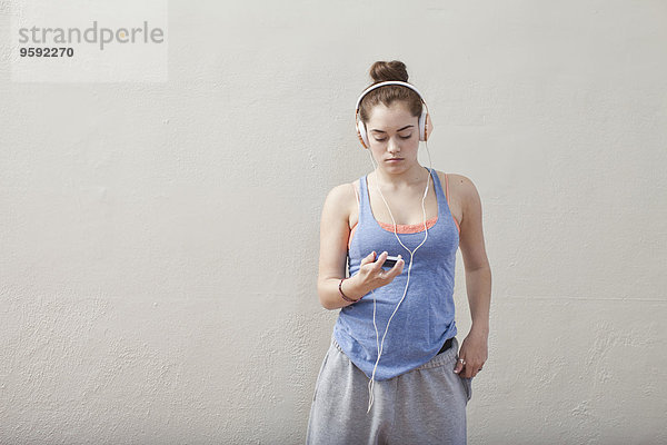 Teenager-Mädchen hört Smartphone-Musik in der Ballettschule
