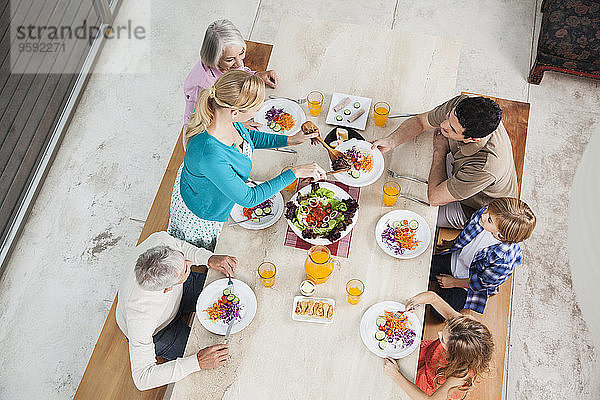 Großfamilie mit Salat und Saft am Esstisch