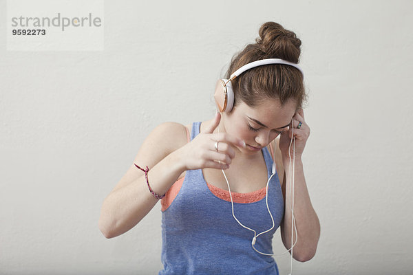 Teenager-Mädchen hört Kopfhörer in der Ballettschule