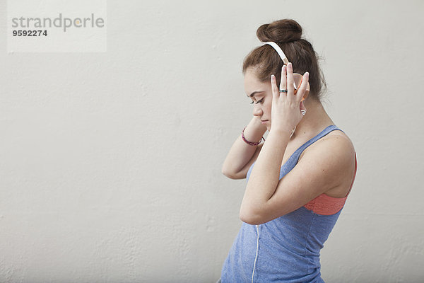 Teenager-Mädchen hört Musik über Kopfhörer in der Ballettschule