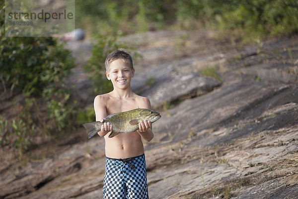 Teenager-Junge hält Smallmouth Bass Fisch  Lake Superior  Au Train Bay  Michigan  USA
