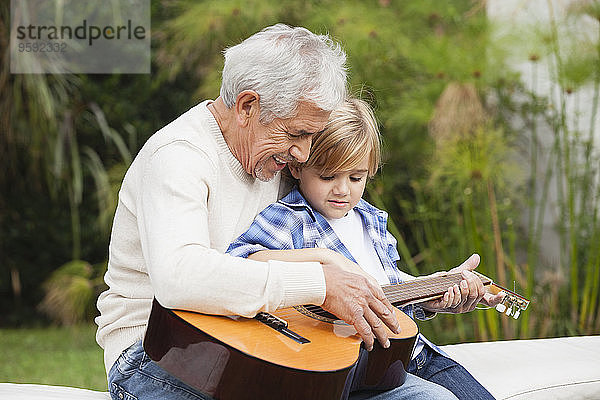 Großvater und Enkel mit Gitarre im Freien