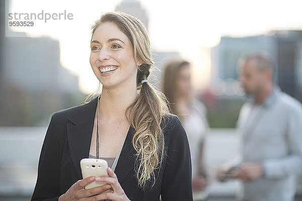 Porträt einer lächelnden Geschäftsfrau mit Smartphone