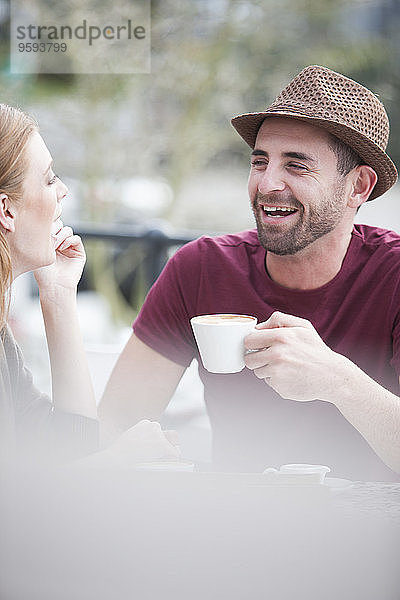 Porträt eines lachenden Mannes bei einer Kaffeepause mit seiner Freundin