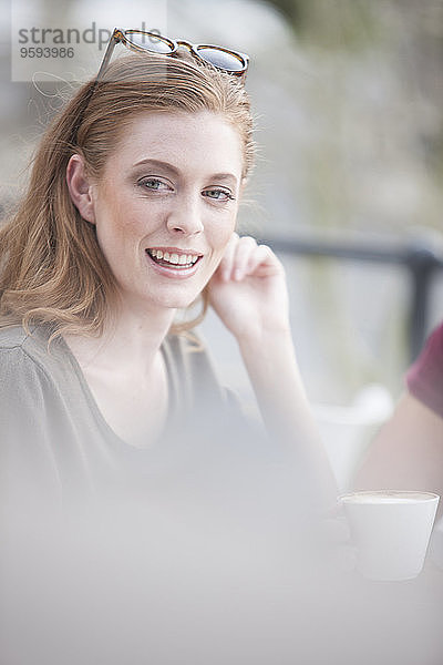 Porträt einer lächelnden jungen Frau bei einer Kaffeepause