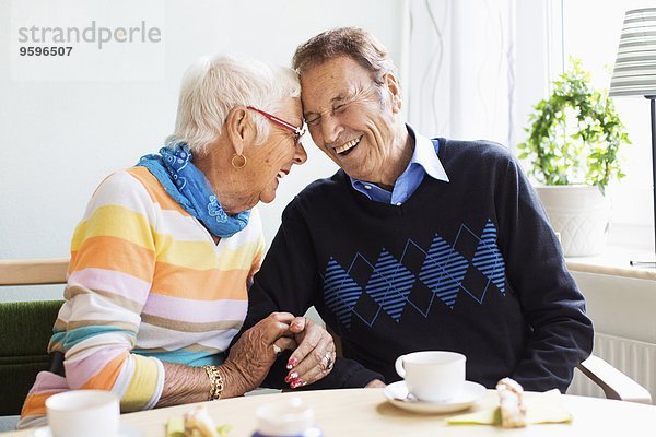 Liebevolles Seniorenpaar lacht im Pflegeheim