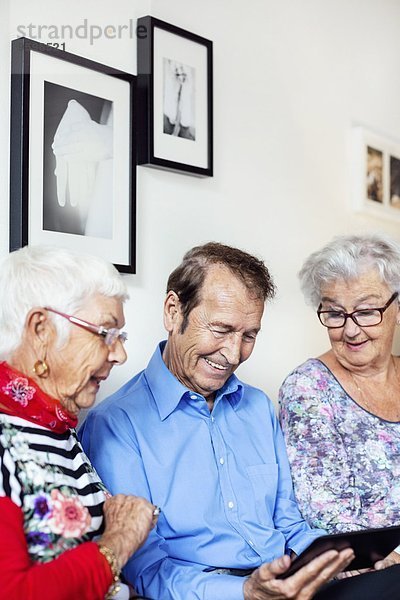Zufriedene Senioren mit dem digitalen Tablett im Pflegeheim