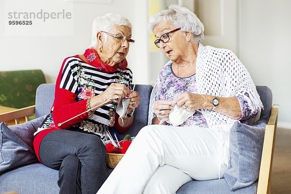 Seniorinnen diskutieren beim Stricken im Pflegeheim