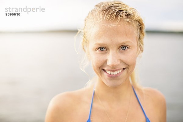 Porträt einer lächelnden jungen Frau gegen den See