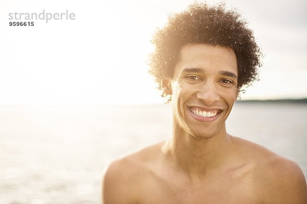 Porträt eines glücklichen jungen Mannes gegen den See