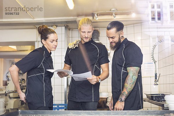 Arbeiter beim Lesen von Dokumenten im Süßwarenladen