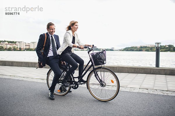 Glückliche Geschäftsleute auf dem Fahrrad in der Stadtstraße