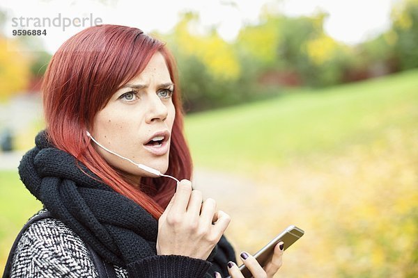Mittlere erwachsene Frau beim Telefonieren im Park