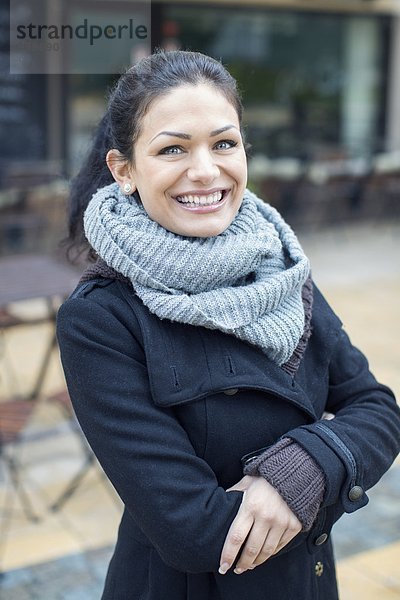 Porträt einer lächelnden mittleren erwachsenen Frau im Outdoor-Café