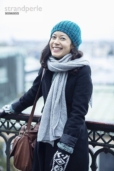 Porträt einer glücklichen Frau am Geländer stehend