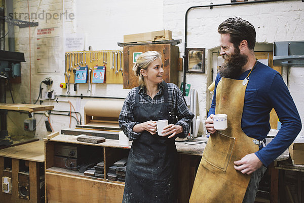 Handwerker und Frau beim Plaudern in der Pfeifenorgel-Werkstatt