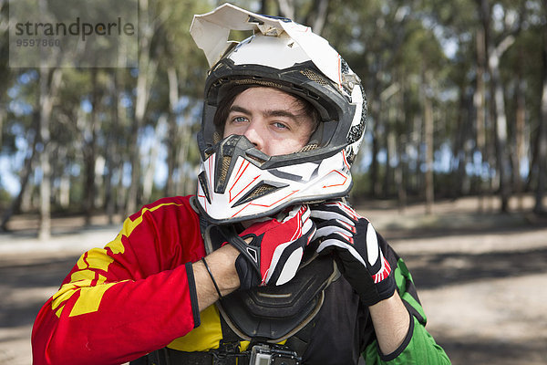 Motocross Motorrad-Wettbewerber Befestigung Helm im Wald