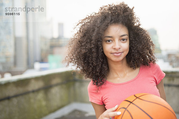 Junge Frau hält Basketball