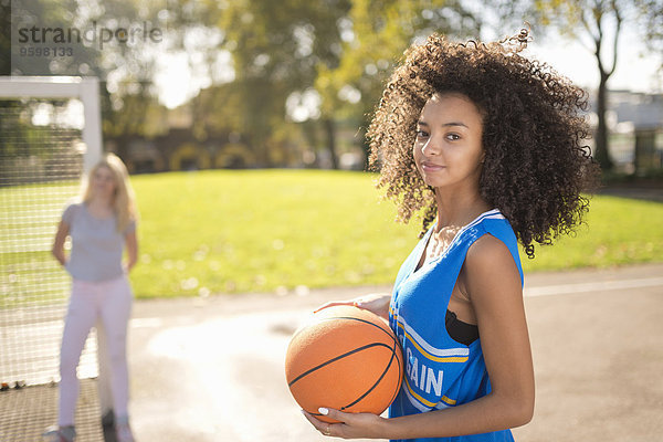 Porträt einer jungen Frau  die Basketball hält
