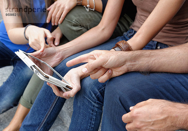 Gruppe von Freunden  die sich das digitale Tablett anschauen  konzentrieren sich auf Tablett und Hände
