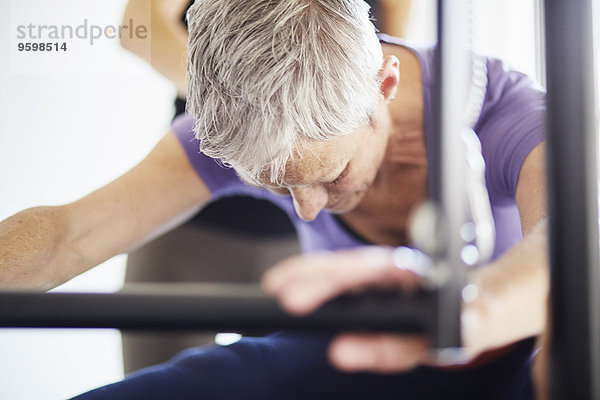 Nahaufnahme der Frau  die Pilates auf dem Trapeztisch in der Pilates Turnhalle praktiziert.