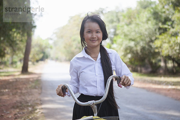 Kambodscha Mädchen mit ihrem Fahrrad auf der Landstraße  Siem Reap  Kambodscha