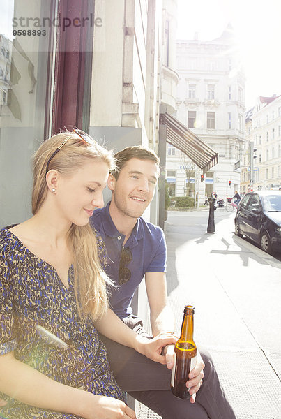 Junges Paar im Straßencafé beim Biertrinken