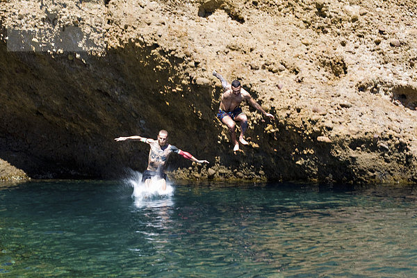 Zwei junge Männer  die von Felsen ins Meer springen  Marseille  Frankreich