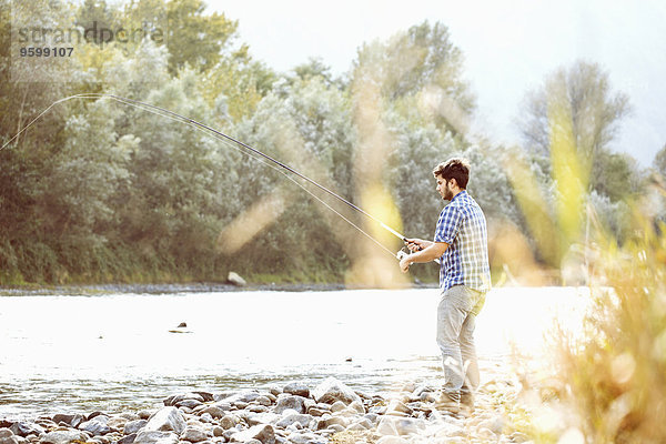Junger Mann beim Fischen im Fluss  Premosello  Verbania  Piemonte  Italien
