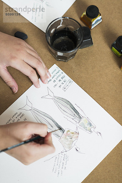 Junge Frauen Hände malen Modedesign auf Arbeitstisch