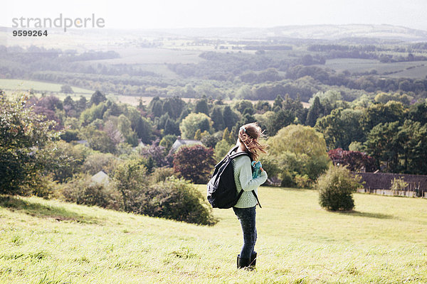 Mädchen steht im Feld und schaut auf die Aussicht