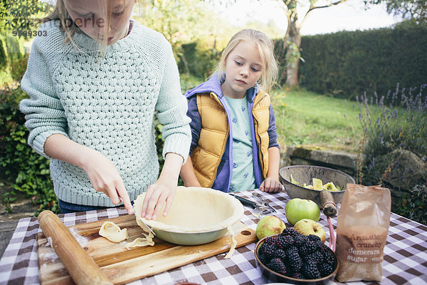 Zwei Mädchen machen einen Kuchen