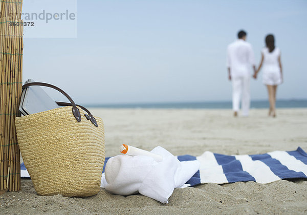 Strandutensilien im Sand  Pärchen im Hintergrund