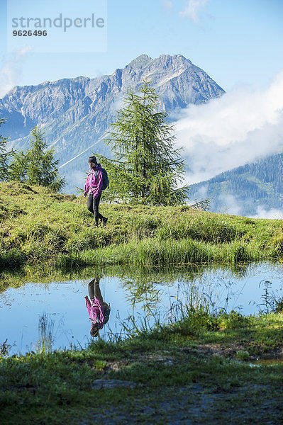 Österreich  Altenmarkt-Zauchensee  junge Frau beim Wandern in alpiner Landschaft