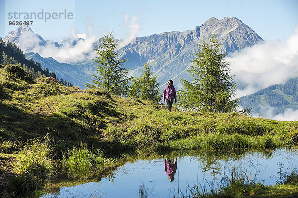 Österreich  Altenmarkt-Zauchensee  junge Frau beim Wandern in alpiner Landschaft