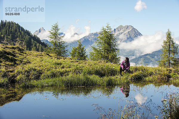 Österreich  Altenmarkt-Zauchensee  junge Frau beim Wandern in alpiner Landschaft