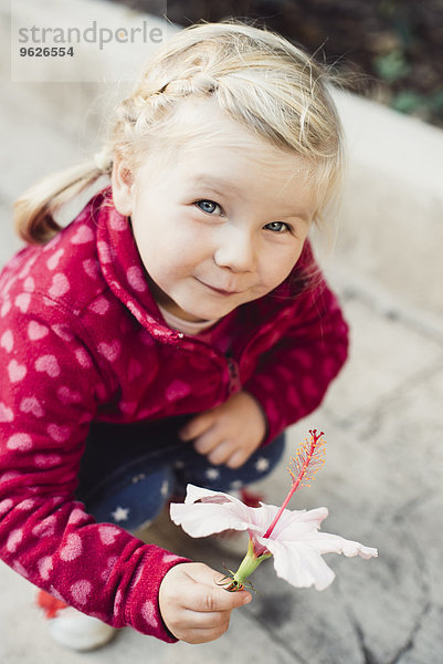 Porträt des kleinen blonden Mädchens mit Hibiskusblume