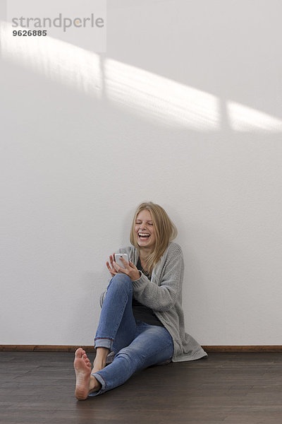 Lachende junge Frau mit Smartphone