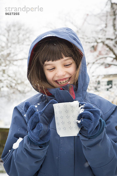 Porträt des lächelnden Mädchens mit Tasse Tee im Winter